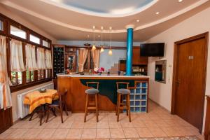 a kitchen with a bar with stools and a table at Golden Sun in Agios Ioannis Pelio