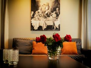 a living room with a couch and a table with roses at Le Petit Château in Baye