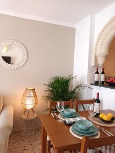 a dining room with a wooden table with plates and wine glasses at Hotel Nou Can Guillem in Cala Figuera