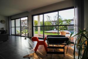 a living room with two chairs and a large window at La Villa des Temps Modernes in Albi