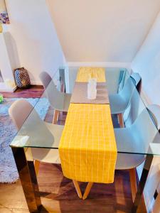 a glass table with chairs and a vase on top of it at Primrose House in Whitefield