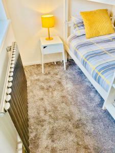 a bedroom with a bed and a table with a lamp at Primrose House in Whitefield +9 photos