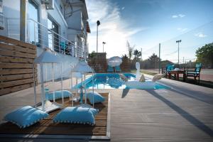 a swimming pool with blue pillows next to a building at Le petit luxury apartment in Preveza