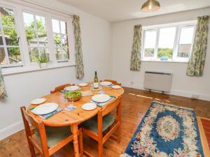 a dining room with a table and chairs and windows at Ladylands Cottage in Newport +36 photos