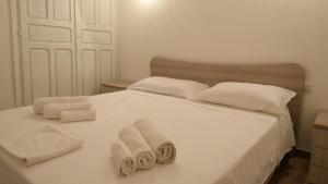 - un lit blanc avec des serviettes dans l'établissement Welcomely - Villa Paola B, à Costa Rei