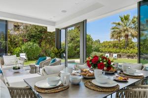 ein Esszimmer mit einem Tisch mit Blumen darauf in der Unterkunft All About Villa Gladiolo in Marbella