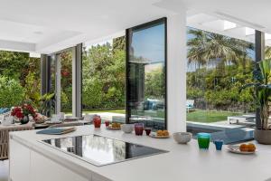 eine Küche mit weißen Arbeitsflächen und großen Fenstern in der Unterkunft All About Villa Gladiolo in Marbella