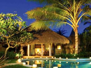 a resort with a swimming pool and palm trees at Novotel Lombok Resort & Villas in Kuta Lombok