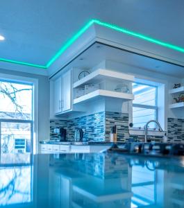 eine Küche mit Spüle und eine Küche mit blauer Beleuchtung in der Unterkunft Big Home/Pet/Free Parking/EV/6 Br Sleeps 25/dwntwn in Houston