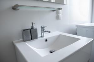 - un lavabo blanc dans la salle de bains blanche dans l'établissement Chopin's Apartment, à Bielsko-Biała
