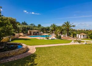 um grande quintal com uma piscina e um resort em Quinta das Castelhanas, Jardim Relvado, Piscina, Padel e Golf privados! em Portimão