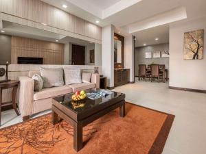 a living room with a couch and a table at Grand Mercure Bangkok Asoke Residence in Bangkok
