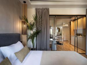 a bedroom with a white bed and a kitchen at Lithinon Luxury Suites Old Town Chania free on-site Parking in Chania