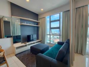 een woonkamer met een bank en een televisie bij Infini Suites@ The Robertson Bukit Bintang in Kuala Lumpur