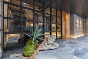 a building with a plant in front of a window at HOTEL THE FLAG Shinsaibashi in Osaka