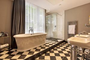 a bathroom with a large tub and two sinks at Edgbaston House in Birmingham