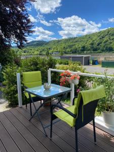 a patio with two chairs and a table on a deck at Villarheinblick in Kamp-Bornhofen