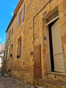 ceglany budynek z drzwiami i garażem w obiekcie La maison de Lily au cœur de la cité Médiévale w mieście Sarlat-la-Canéda