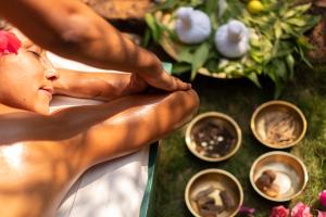 a woman getting aorative massage in front of flowers at SwaSwara Wellness - A CGH Earth Experience, Gokarna in Gokarna