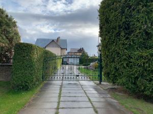 a gate to a driveway with a house at Green house Ramuciai in Ramučiai