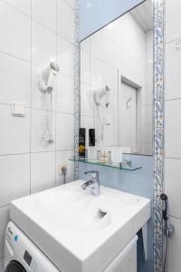 ein weißes Badezimmer mit einem Waschbecken und einem Spiegel in der Unterkunft Vesta in Sankt Petersburg