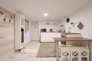 a kitchen with white walls and a table with chairs at COSY COTTAGE - Cheerful Apartment in the Center in Budapest