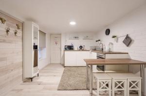 cocina con paredes blancas y mesa con sillas en COSY COTTAGE - Cheerful Apartment in the Center en Budapest