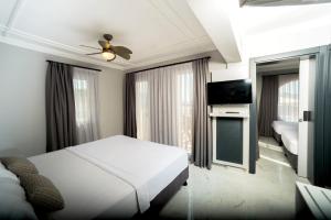 a bedroom with a bed and a flat screen tv at Art Suites Hotel in Yalıkavak