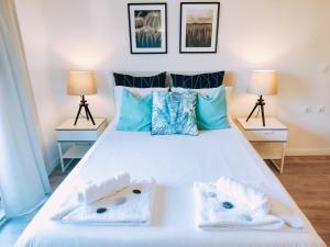 a bedroom with a large white bed with two lamps at The Surf Studio - Ericeira in Ericeira