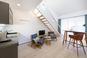 a kitchen and a living room with a staircase at Alpin Chalet Trinkl - adults only ab 16 Jahren in Bad Wiessee