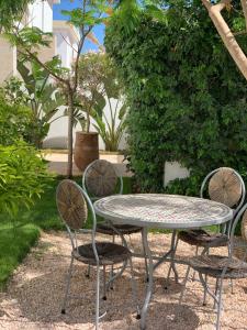 three chairs and a table and a table and chairs at Villa 96 Taghazout Bay in Taghazout