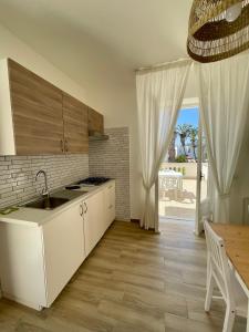 a kitchen with a sink and a table and a window at Residence San Domenico in Ischia