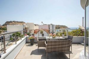 a patio with a table and chairs on a balcony at Haraki Blue Dream Luxury Apartments in Haraki