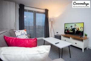 a living room with a couch and a flat screen tv at Cocooonstays Short Lets & Accommodation Slough in Slough