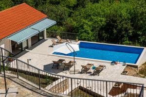 an overhead view of a swimming pool with chairs and a table at Villa Konavoski Miri in Gruda