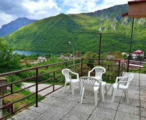a table and chairs on a balcony with a view of a mountain at Apartman Sofija in Plužine