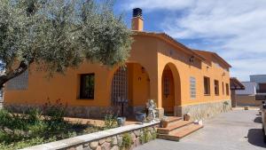 un edificio amarillo con un árbol delante de él en Casa Martina, en Cardedeu