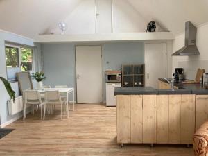 a kitchen with a counter and a table with chairs at The Bee - Trekkershuts & Apartment in Opperdoes +53 photos