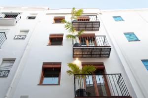 - un bâtiment blanc avec balcon et palmiers dans l'établissement Boho Apartments, à Peñíscola