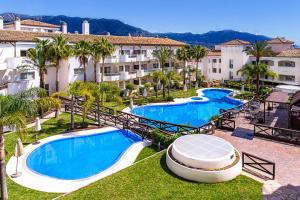 ミハスにあるAparthotel Cordial Mijas Golfのリゾートの空中を望む2つのプールが備わります。