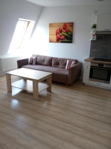 sala de estar con sofá y mesa de centro en Tulip Jagiellonska - poddasze bez windy, en Szczecin
