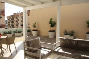 a balcony with chairs and tables and potted plants at Naturelais in Monopoli