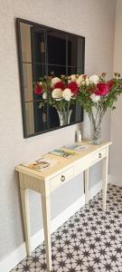 a dressing table with a mirror and flowers on it at La Rua 25 in Castro-Urdiales