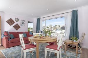 a living room with a table and a red couch at Brixham Breeze in Brixham
