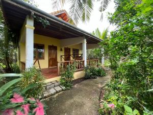 een klein geel huis met een veranda bij Phu Quoc Pomelo Garden in Phu Quoc