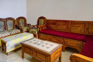 uma sala de estar com mobiliário em madeira e uma mesa em OYO Homes 91132 Desa Wisata Kalipucang em Nongkejajar