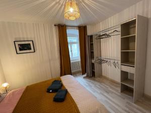 um quarto com uma cama com dois sapatos pretos em Ca s'est passé à la Cour-Aux-Moines em Porrentruy