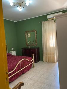a bedroom with a bed and a mirror on the wall at Casa Eoliana in Taormina