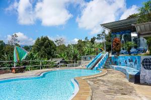 a swimming pool with a slide in a resort at OYO Homes 91132 Desa Wisata Kalipucang in Nongkejajar