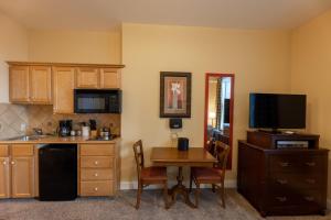 a kitchen with a small table and a television at Seneca Unit 102 in Snowshoe